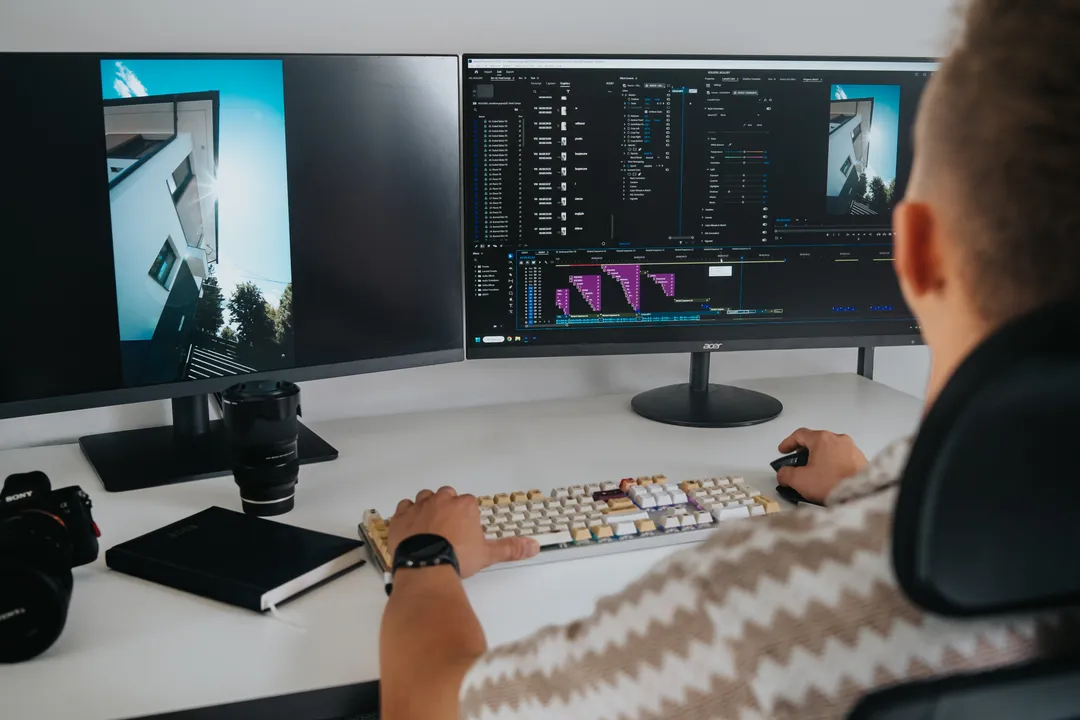Marcel przy montażu i color gradingu na dwóch monitorach